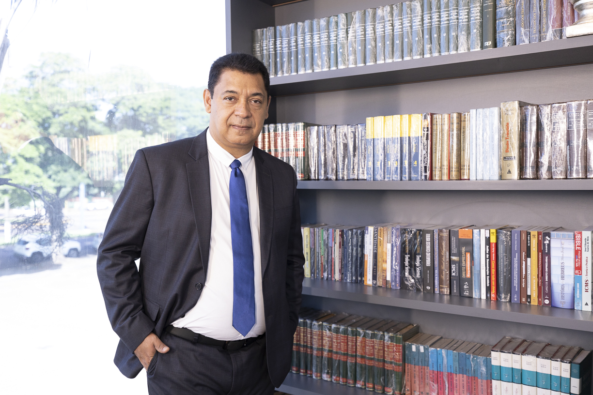 Jacques Cardoso da Cruz diante da biblioteca jurídica do escritório
