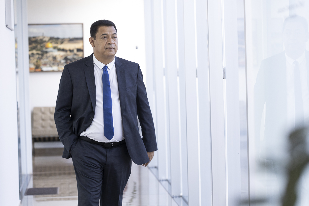Jacques Cardoso da Cruz caminhando pelo corredor do escritório